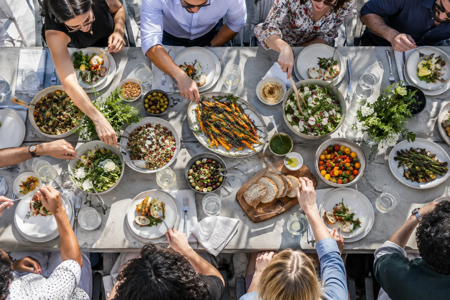 Overhead view of shared plates with hands reaching in